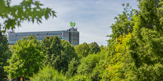 Das Mathematikgebäude mit grünen Bäumen im Vordergrund.