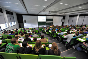 Students sit in a lecture hall in the seminar building at the Campus North.